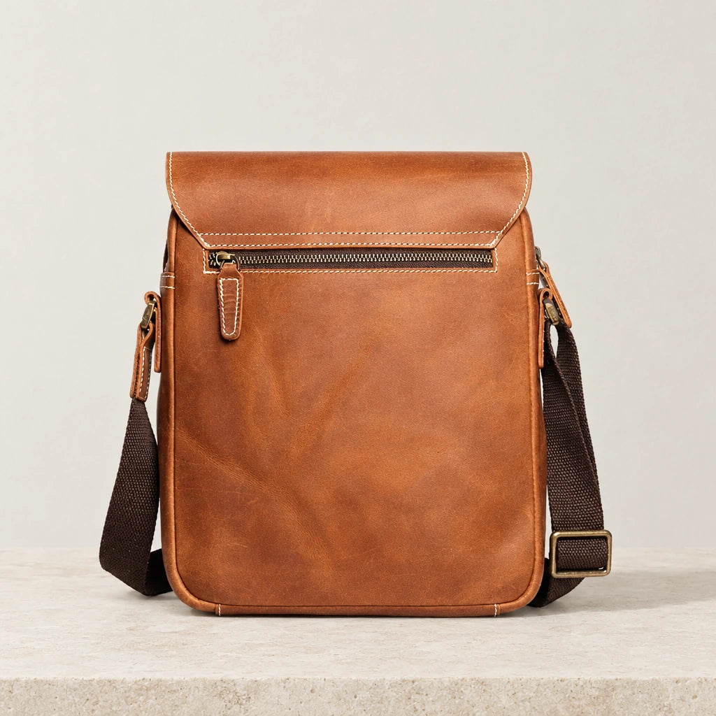 Dos de la sacoche à rabat en cuir marron avec poche zippée