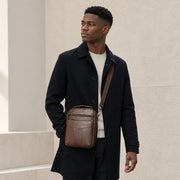 Homme en manteau portant la sacoche de travail marron
